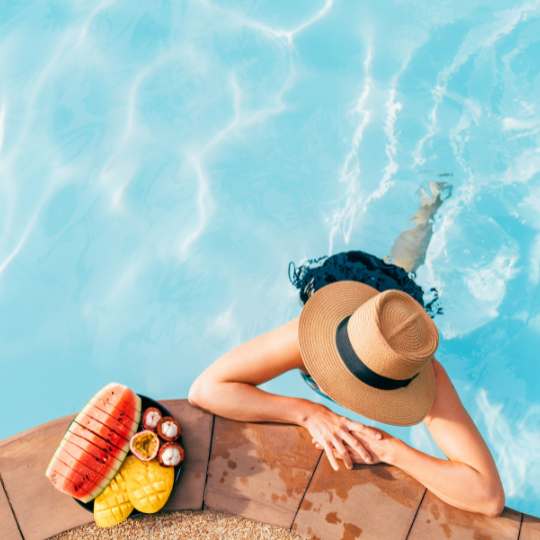 woman eating fresh fruit hanging on to the edge of a south florida pool