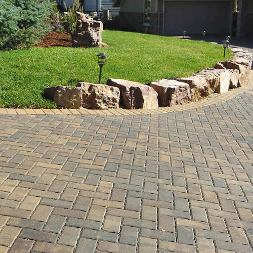 Driveway pavers with boulders along the edges