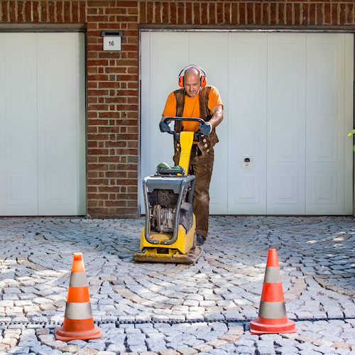 man working on driveway pavers